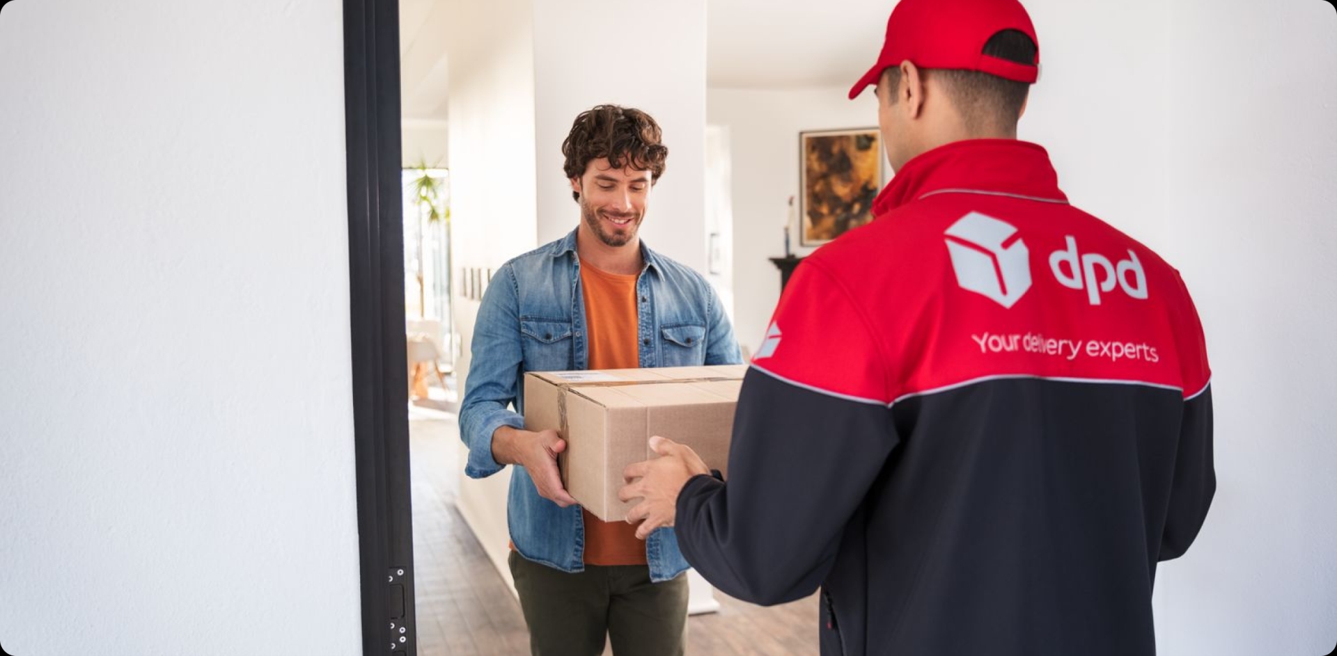 Parcel delivery guy handing over a parcel to a customer at the doorstep